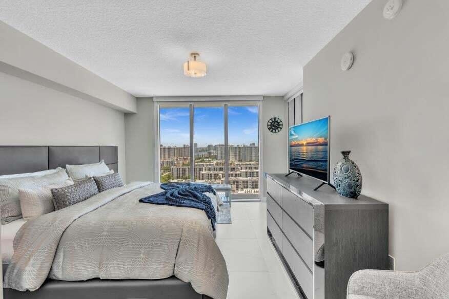 Full-height glass doors, recessed lighting, tile flooring, and a contemporary light fixture