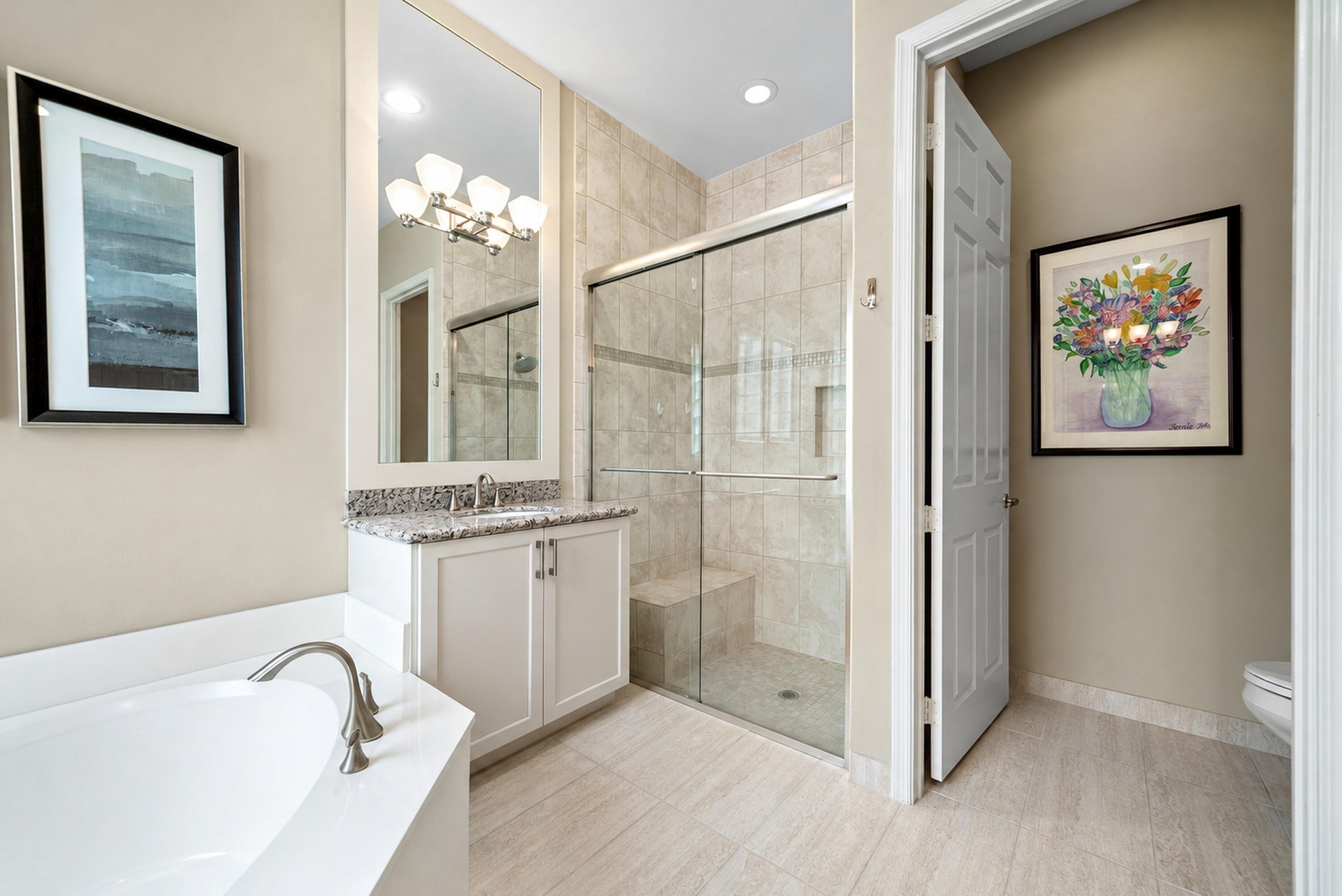 Bathroom featuring a walk-in shower with a glass enclosure and built-in bench, a soaking tub, a vanity with stone-finish countertop, and tiled floorin