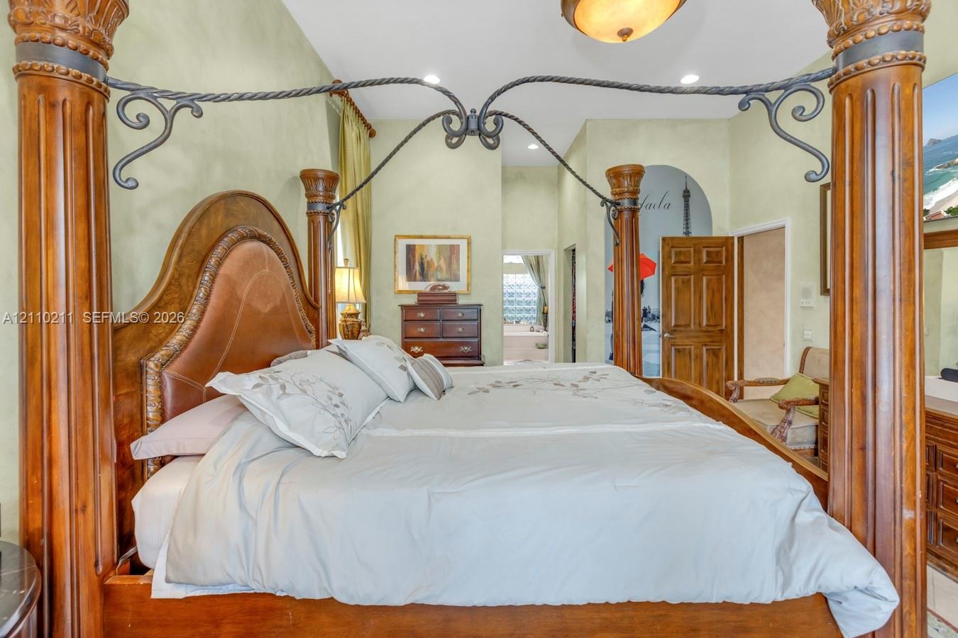 Room featuring recessed lighting, a decorative arched entryway, and raised panel wooden doors