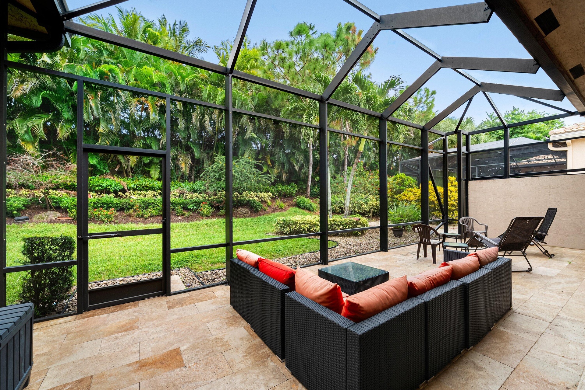 Screened-in patio enclosure featuring stone flooring and metal structural framing