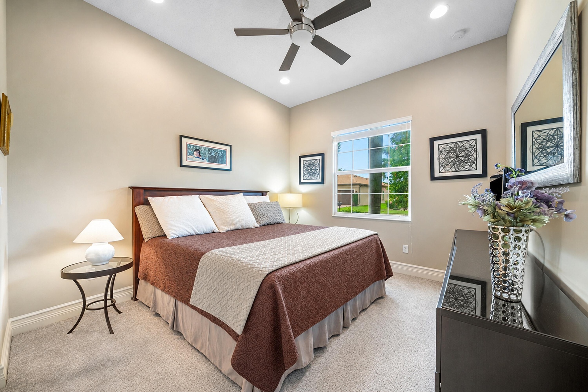 High ceilings featuring a central ceiling fan with integrated lighting, neutral wall palette, plush wall-to-wall carpeting, and a multi-pane window wi