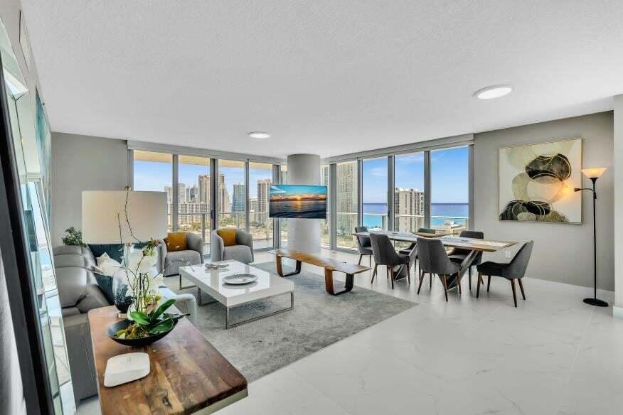 Expansive living area with large format tile flooring, extensive floor-to-ceiling windows, and recessed ceiling lighting