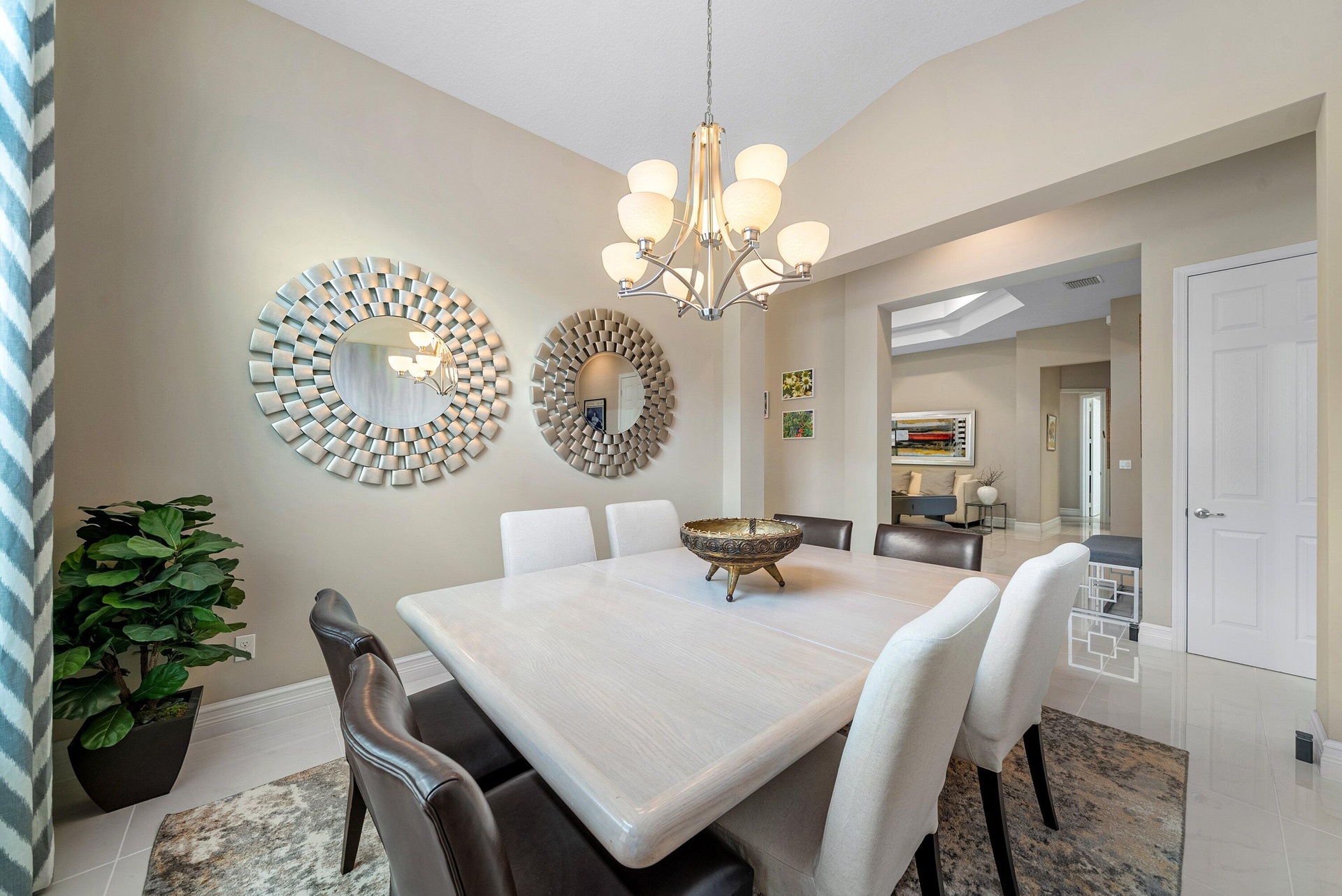 Vaulted ceilings, polished tile flooring, and a multi-arm chandelier with frosted glass shades