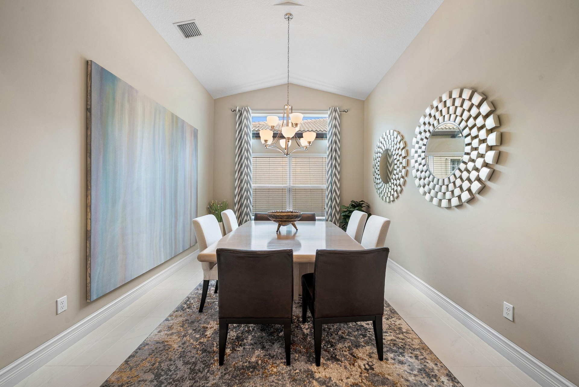 Vaulted ceilings, large-format tile flooring, and a multi-arm metallic chandelier