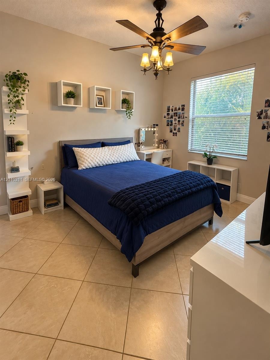 Neutral-toned interior featuring large-format tile flooring, a multi-tiered built-in corner shelf, three square floating wall-mounted shelves, and a c