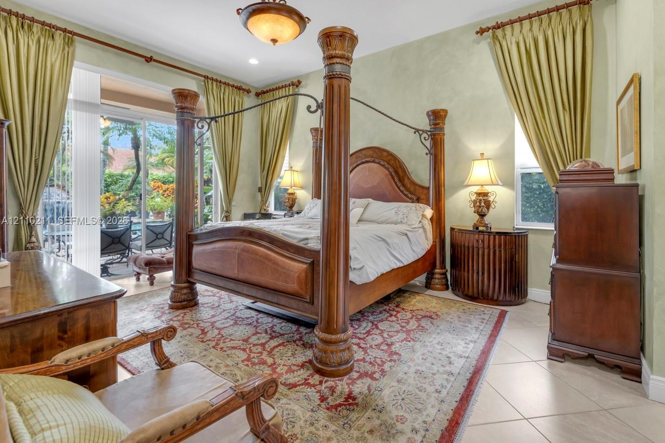 Spacious room featuring tile flooring, textured wall finishes, a decorative central ceiling light fixture, and sliding glass doors providing outdoor a