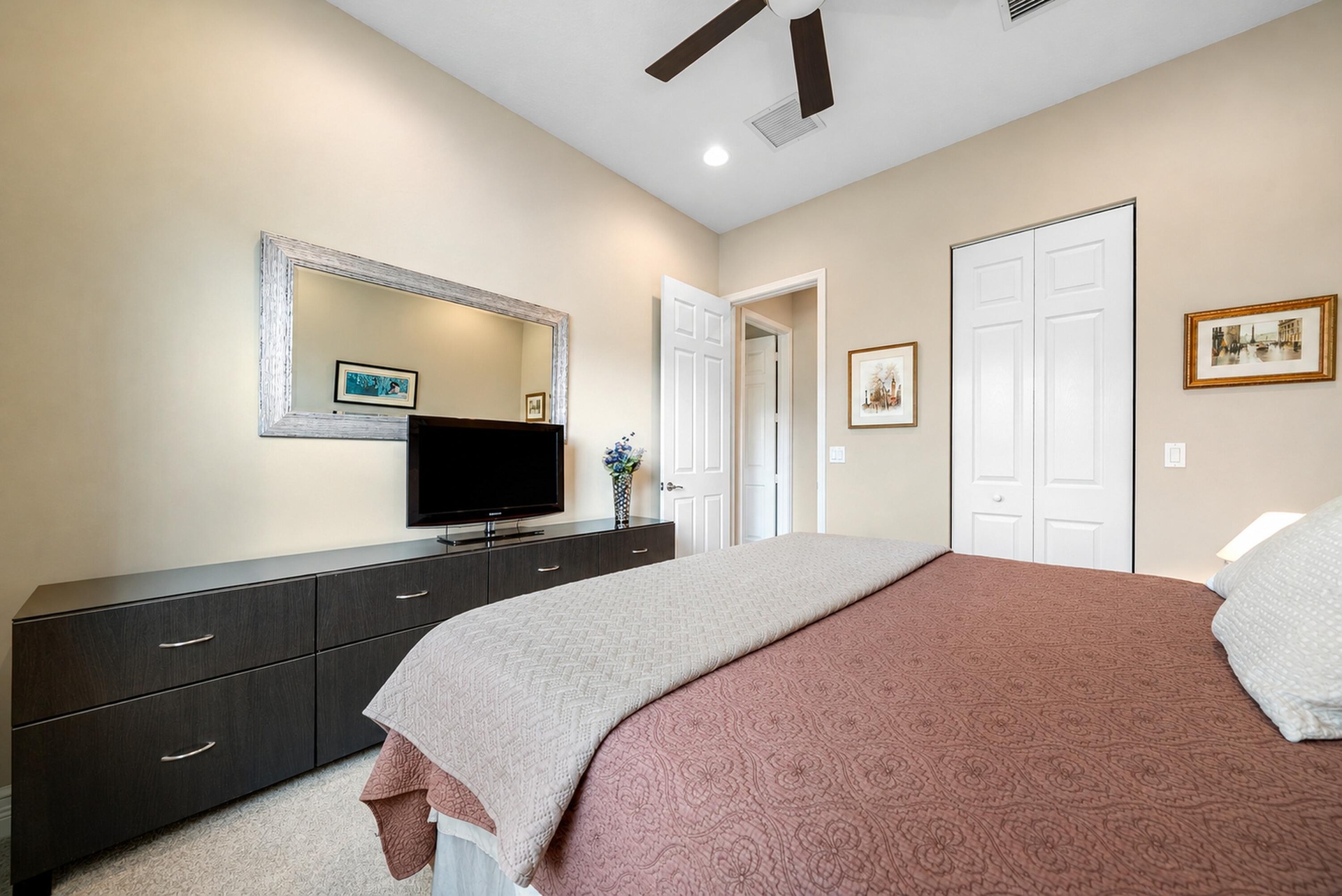 Vaulted ceilings featuring a recessed ceiling fan, neutral wall finishes, carpeted flooring, and bi-fold closet doors