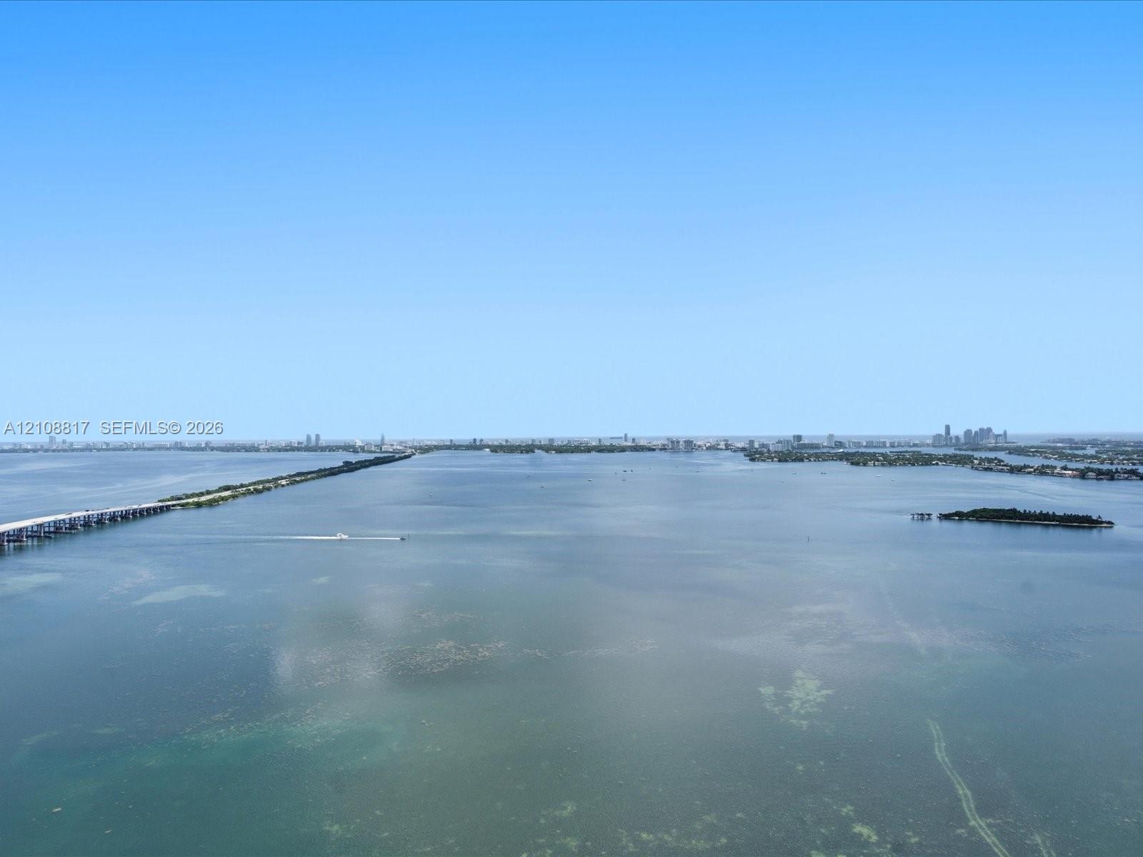 Aerial perspective showcasing expansive water frontage, open horizon, and distant cityscape