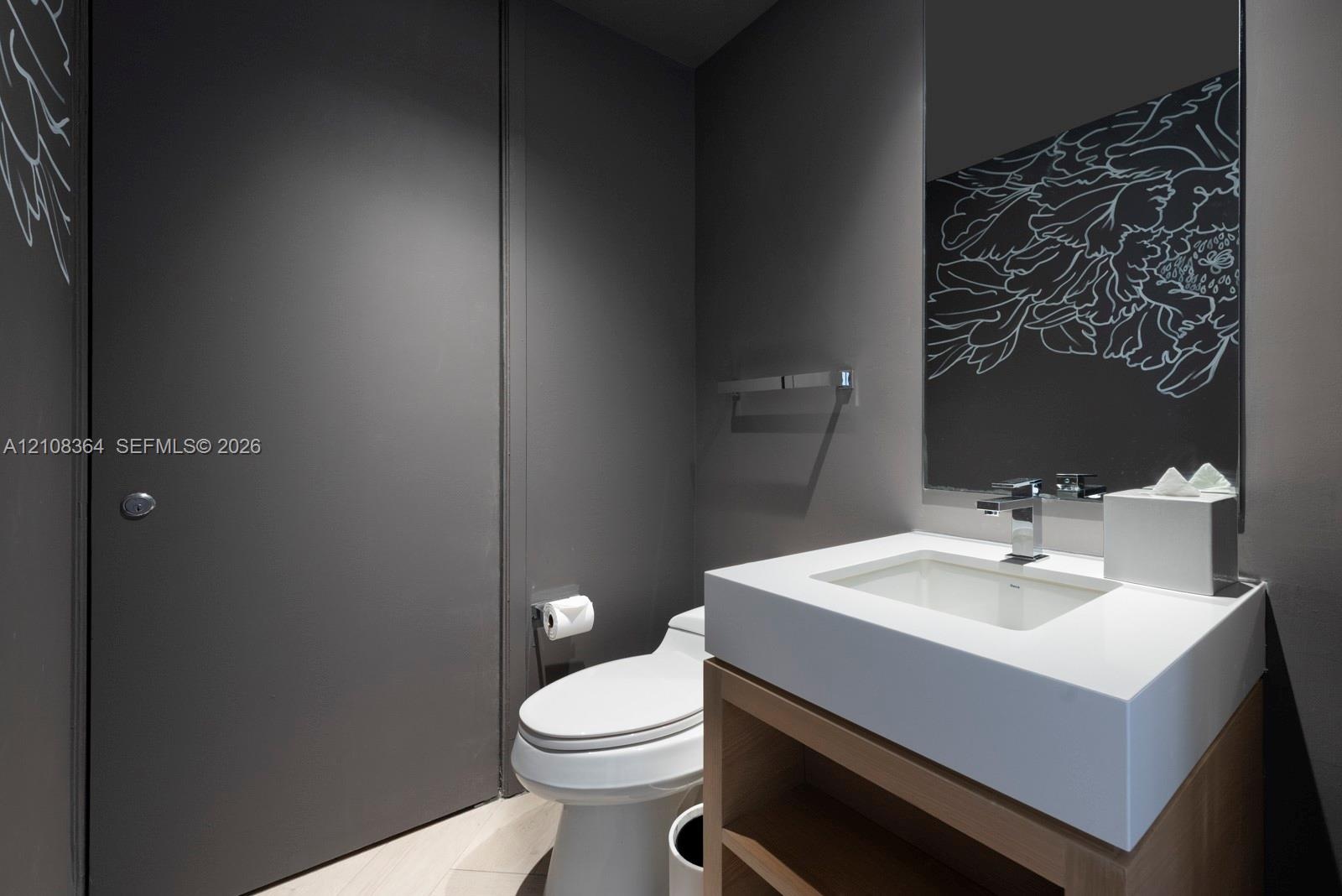Modern vanity featuring an integrated rectangular sink and stone countertop, wood-finish open cabinetry, wall-mounted faucet, and a wall-to-wall mirro