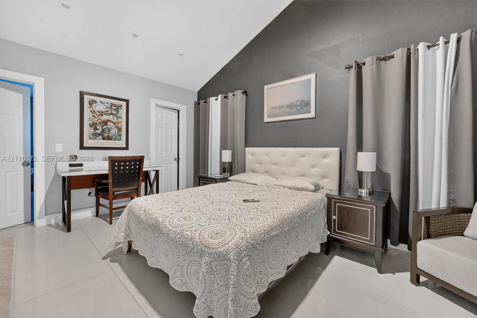 Vaulted ceiling with recessed lighting, large-format tile flooring, and a contrast accent wall