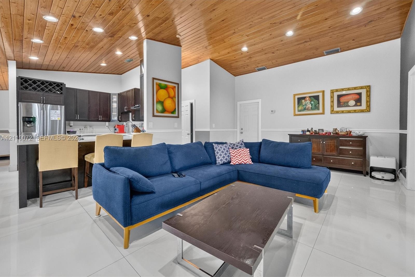 Vaulted tongue-and-groove wood ceiling featuring recessed lighting, polished porcelain tile flooring, and dark-toned cabinetry with integrated wine st