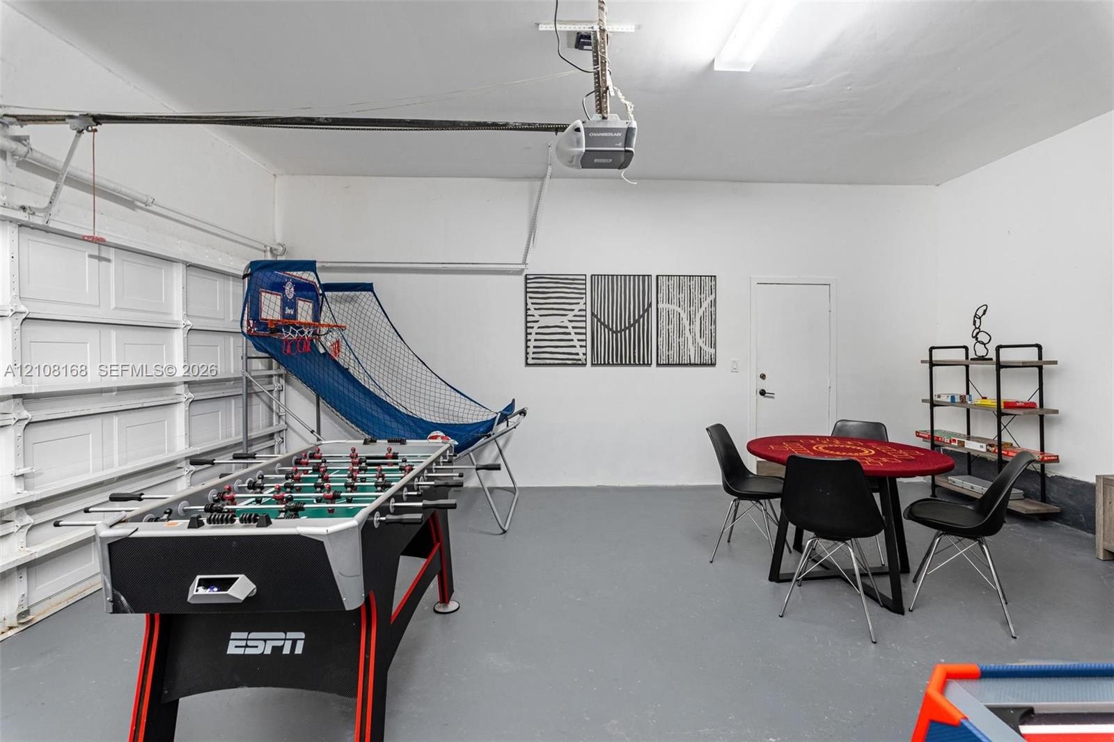 Two-car garage featuring painted walls, smooth-finish concrete flooring, a sectional roll-up door, and an integrated ceiling-mounted garage door opene