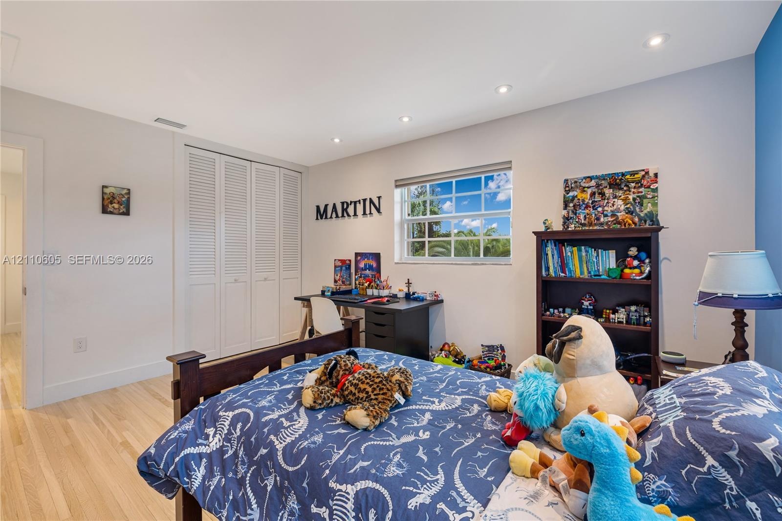 Light-filled room featuring wood-finish flooring, recessed lighting, and a multi-pane window
