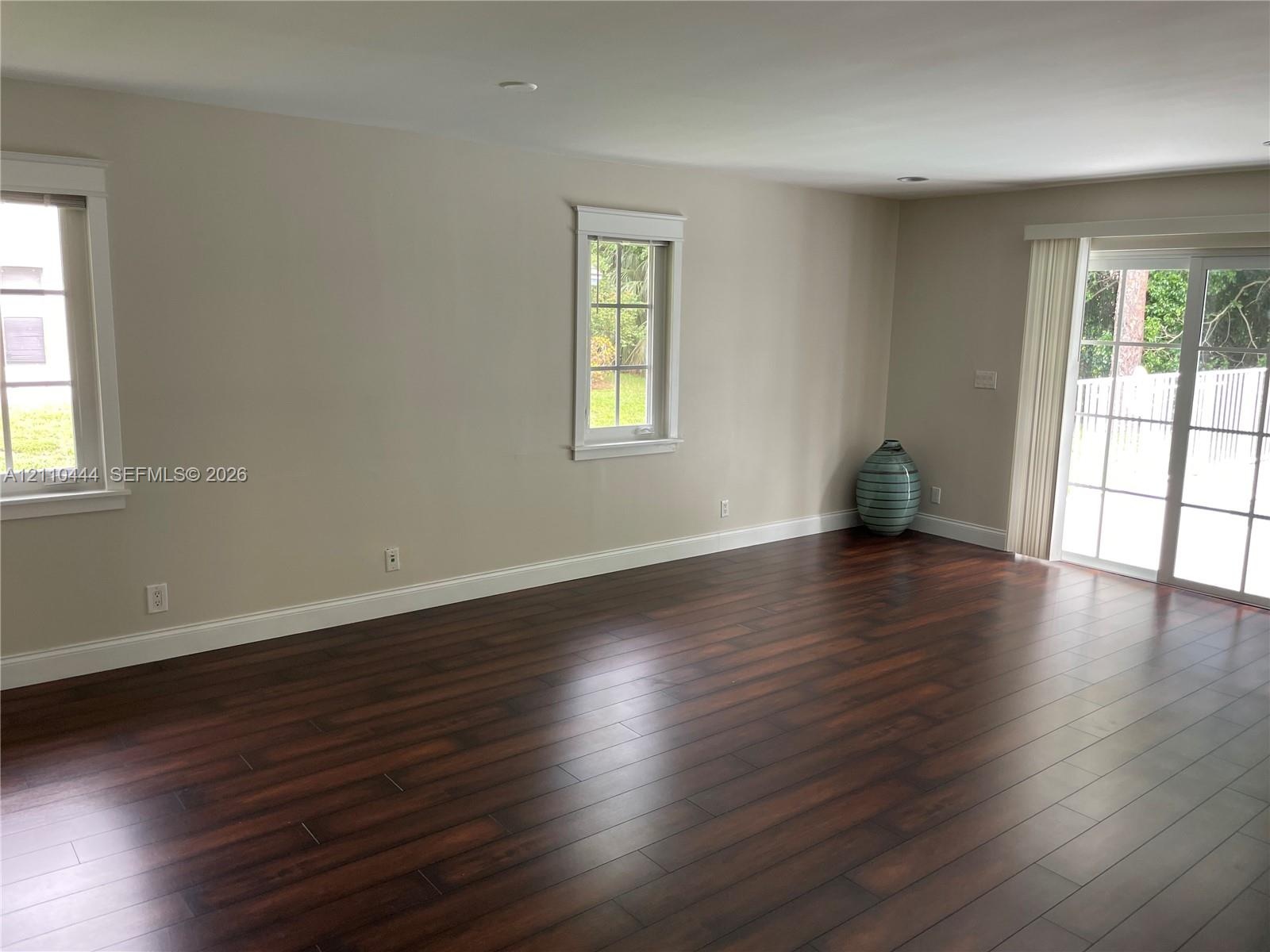 Interior space featuring wood-finish flooring, recessed lighting, double-hung windows with grid detailing, and glass sliding doors