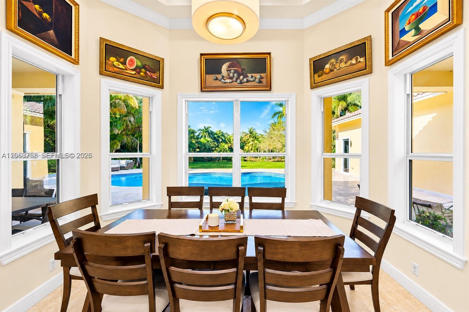 Octagonal breakfast area featuring a tray ceiling, recessed center light fixture, tile flooring, and oversized windows