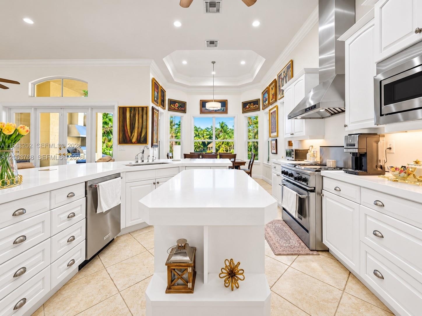 Kitchen featuring a large central island with solid-surface countertops, white shaker-style cabinetry, stainless steel professional-grade appliances, 