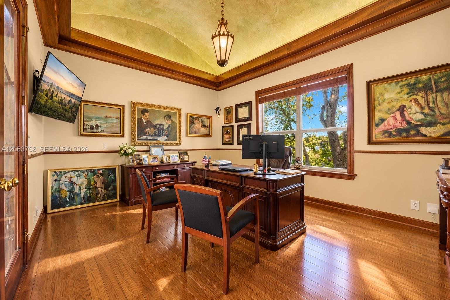 Barrel-vaulted ceiling, wood-finish flooring, custom wood crown molding, chair rail trim, and pendant lighting fixture