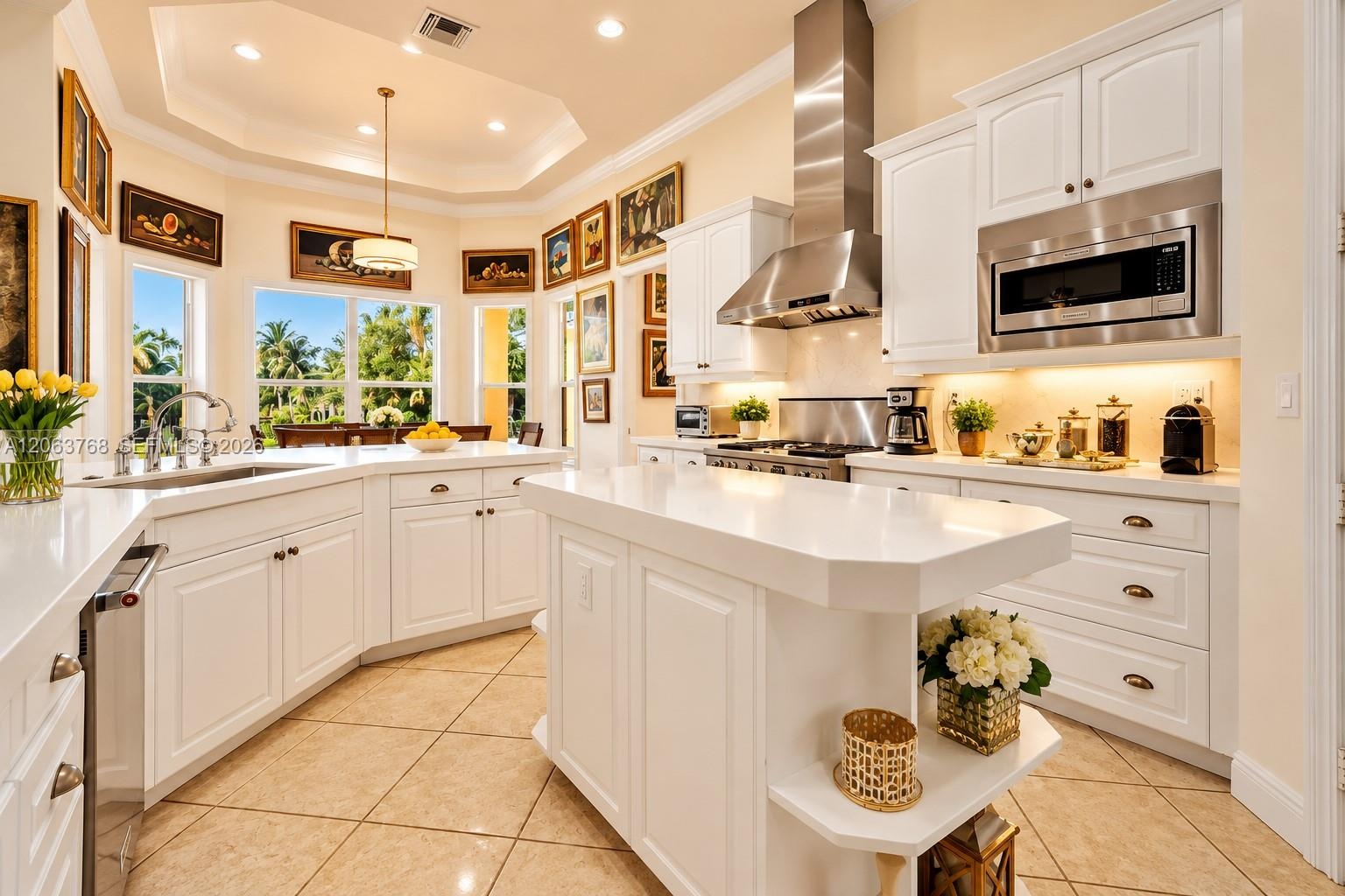 Kitchen featuring white cabinetry, quartz countertops, a center island with built-in shelving, stainless steel appliances, and tile flooring