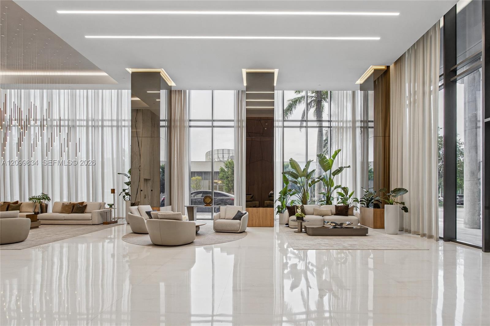 Lobby featuring floor-to-ceiling windows, polished stone flooring, recessed linear lighting, and reflective structural columns