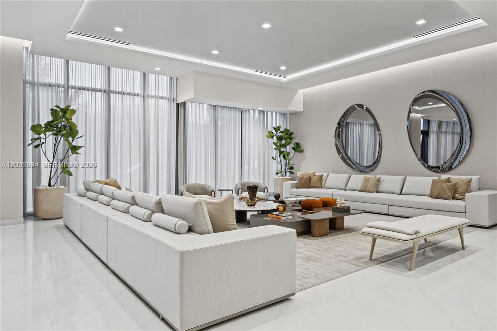 Floor-to-ceiling windows with floor-length drapery, recessed tray ceiling with integrated perimeter lighting, expansive large-format polished flooring