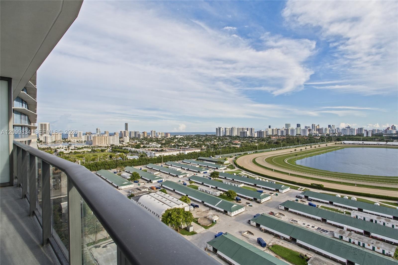 Private balcony featuring a glass panel railing and metal handrail