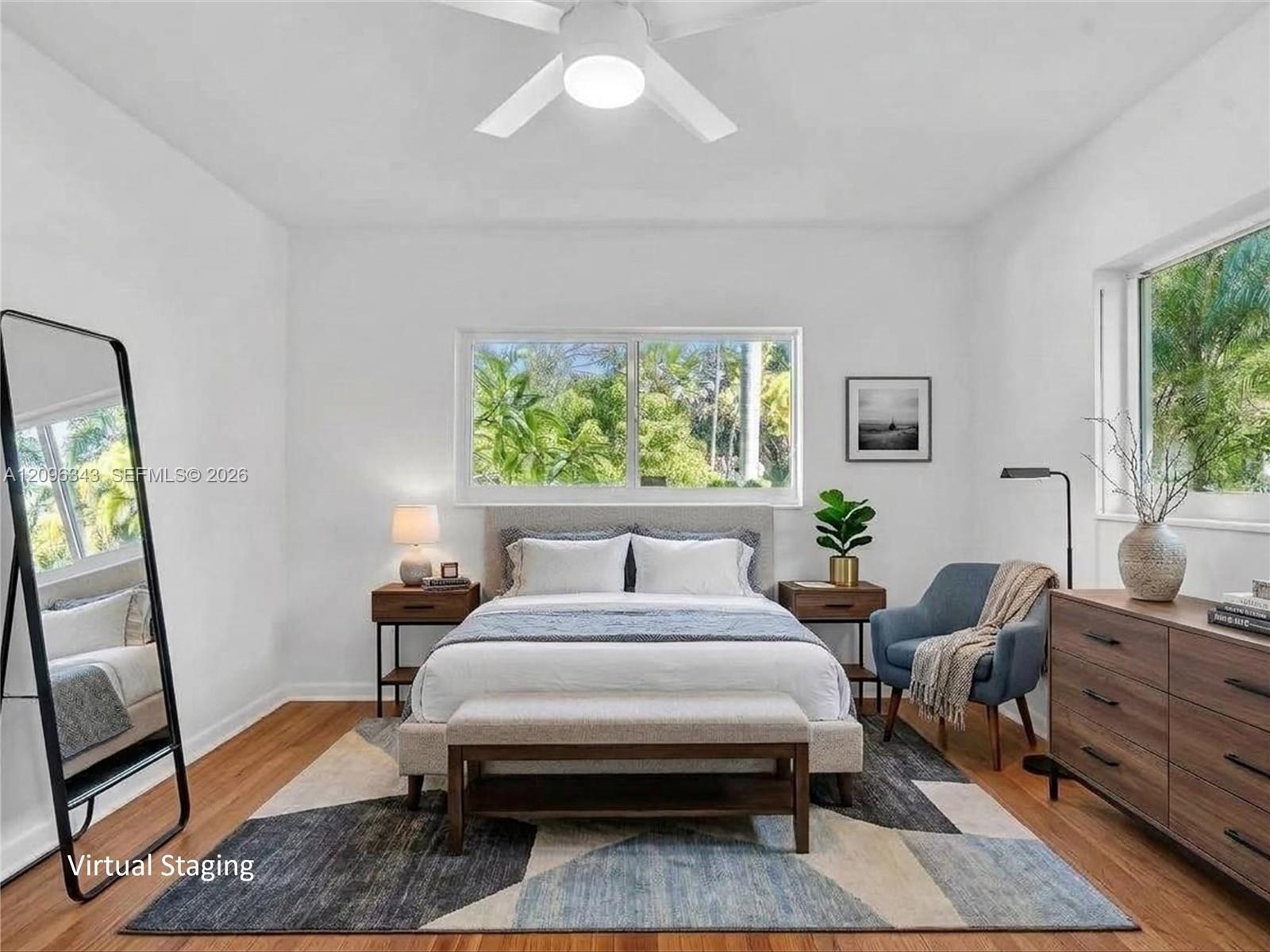 VIRTUALLY STAGED. Front bedroom with bright sunny windows, hard wood floors, and large closet in this home for rent in Coconut Grove in Miami, FL. Nat
