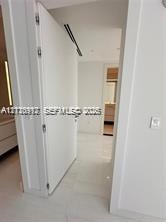 Interior featuring full-height door, neutral tile flooring, recessed ceiling lighting, and linear air distribution system