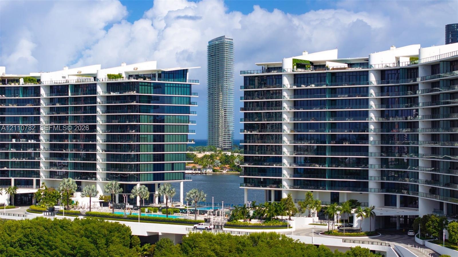 Modern high-rise architecture featuring expansive glass curtain walls, wrap-around balconies, deep-water access, and integrated ground-level swimming 