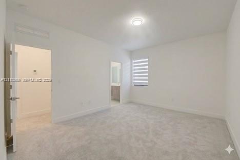Neutral-toned carpeted flooring, flush-mount ceiling lighting, and layered window blinds