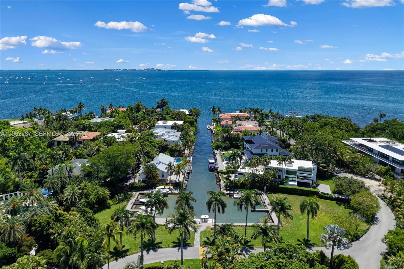 Waterfront residential property featuring direct canal access, deep-water dockage, palm-lined landscaping, and an expansive horizon over the bay