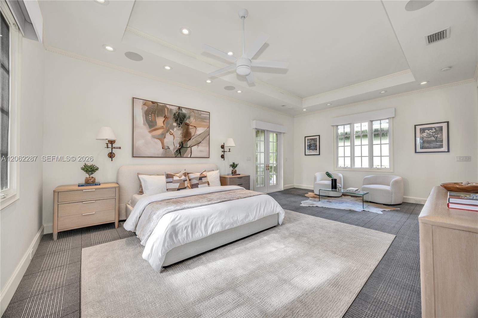 Spacious room featuring a recessed tray ceiling, white multi-blade ceiling fan, integrated recessed lighting, grid-pattern windows, and multi-light Fr