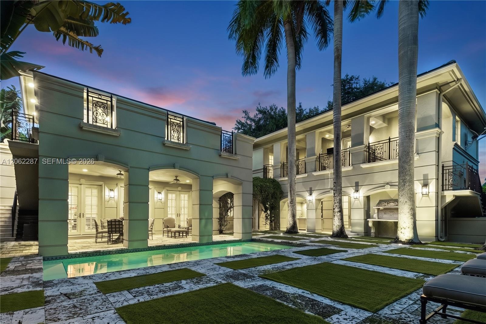 Exterior featuring a pool with stone hardscaping, recessed covered loggias, two-story balconies with ornate metal railings, and a built-in outdoor gri
