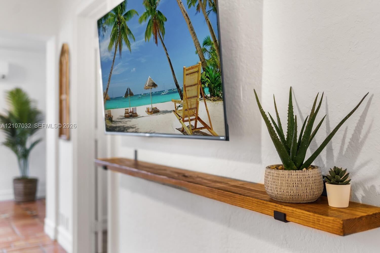 Wall-mounted wood floating shelf with matte black metal brackets and textured white wall finish