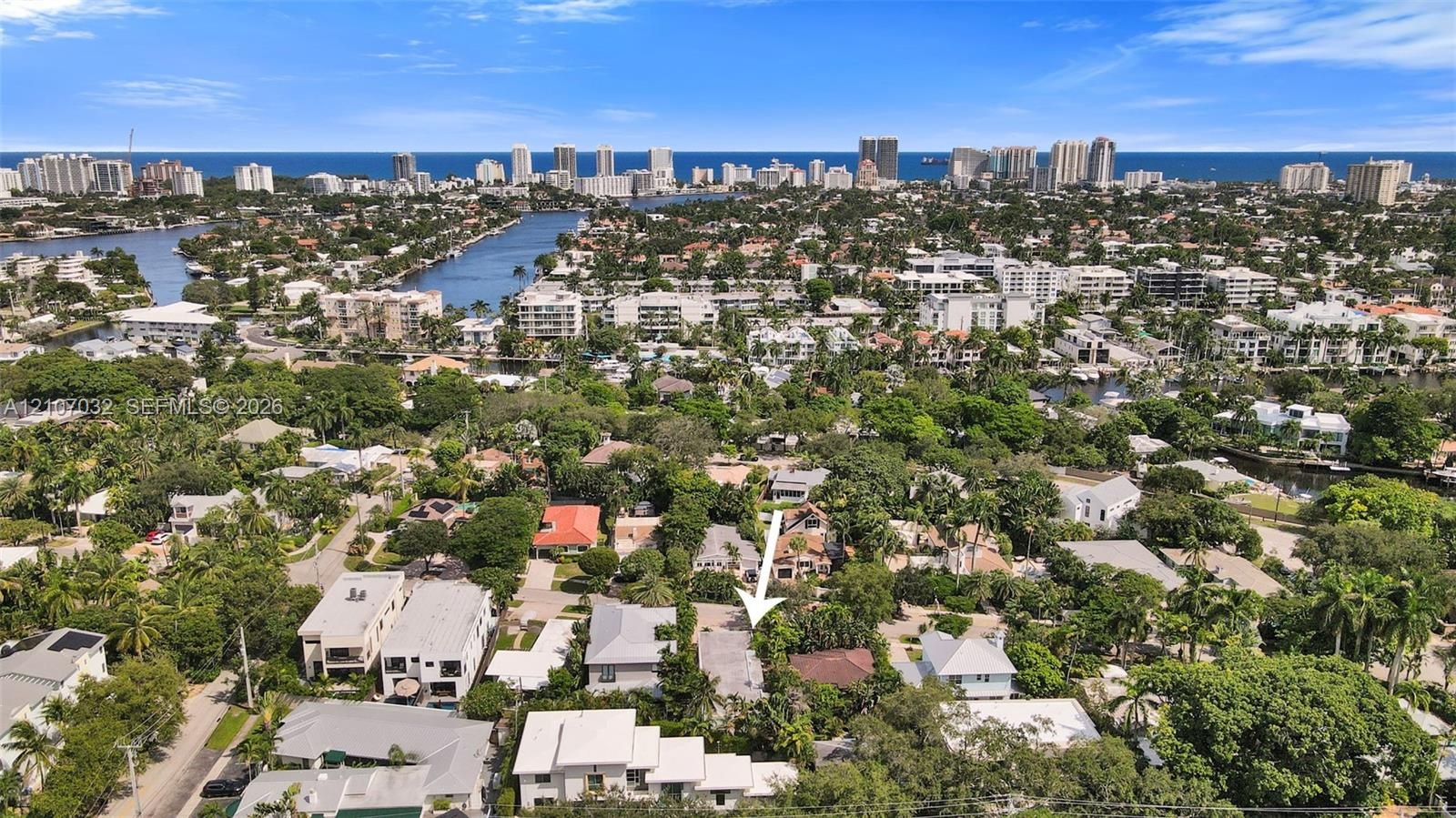 Aerial perspective featuring a residential lot with mature landscaping and proximity to regional waterways and urban coastal infrastructure