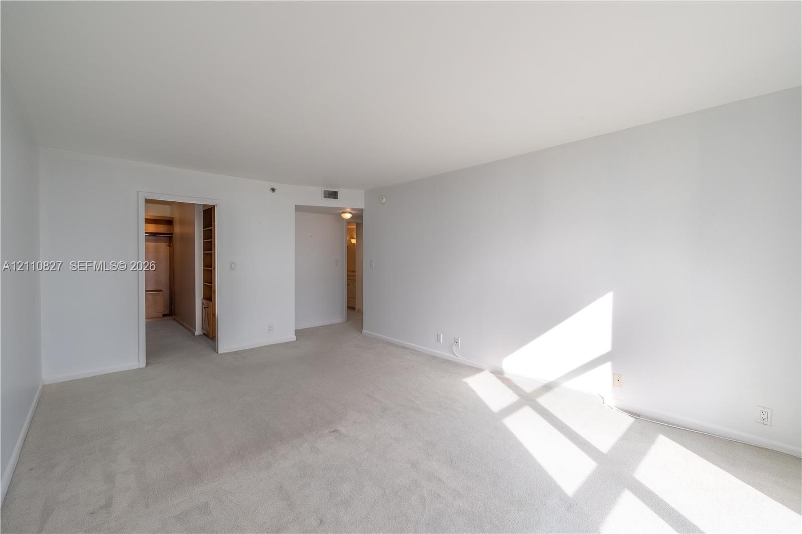 Neutral-toned wall paint, neutral carpeting, and recessed ceiling lighting