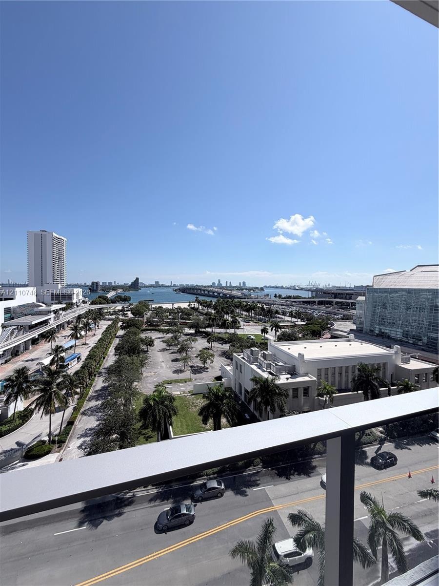 Elevated terrace featuring a metal railing with a wide-angle perspective of the surrounding cityscape, waterfront, and bridge
