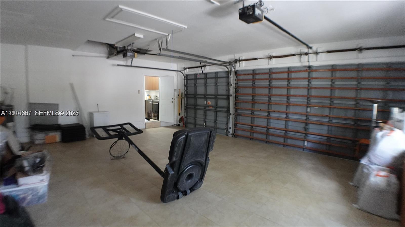 Attached multi-car garage featuring automated door openers and integrated wall-mounted storage shelving