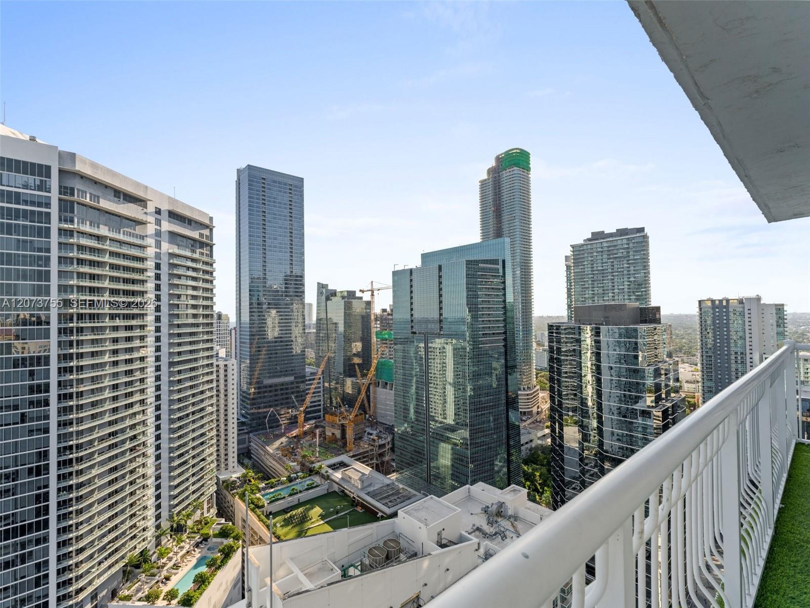Private balcony featuring a metal railing and urban skyline exposure