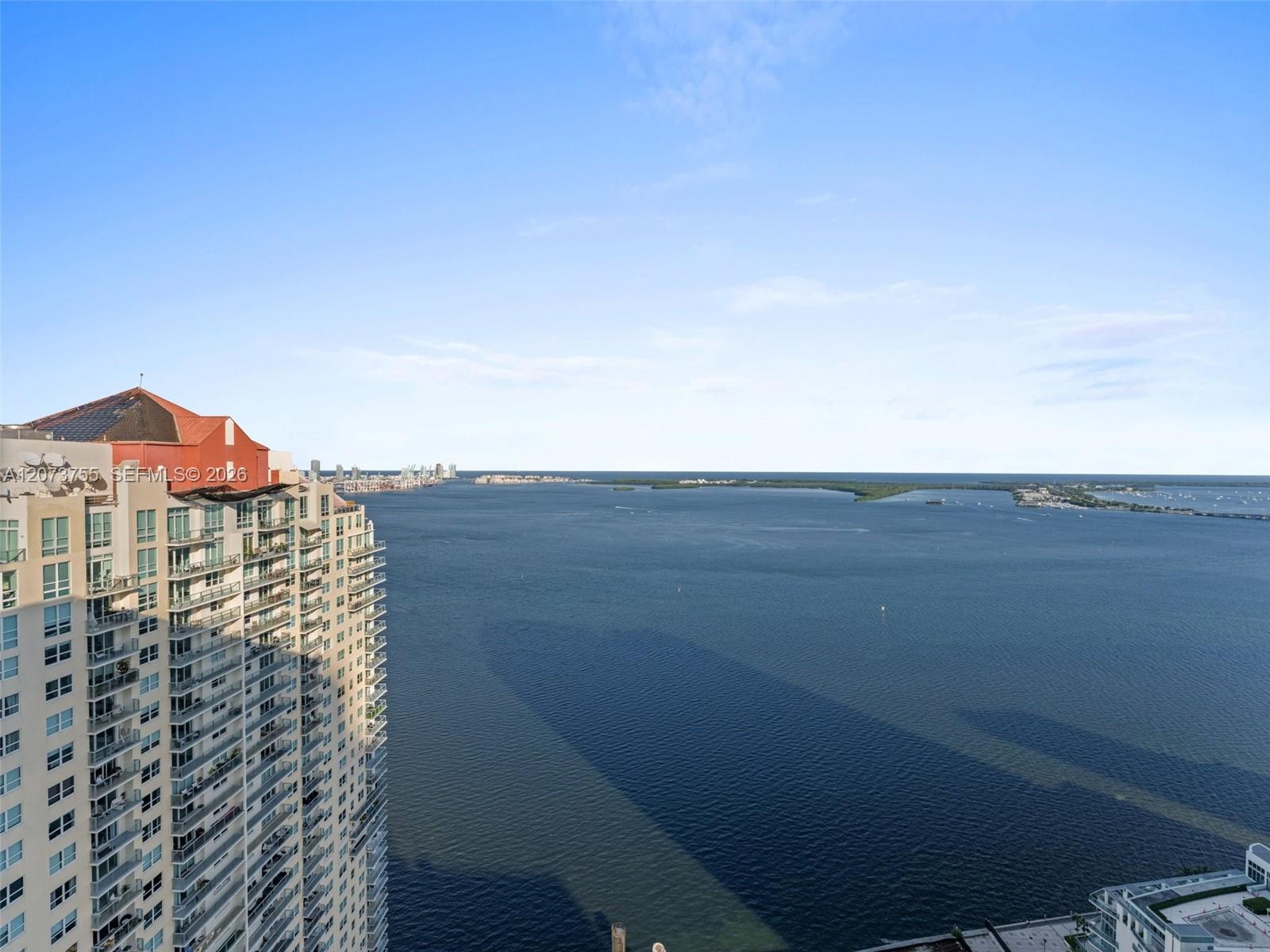 High-rise residential exterior featuring expansive glass balconies and bay water frontage