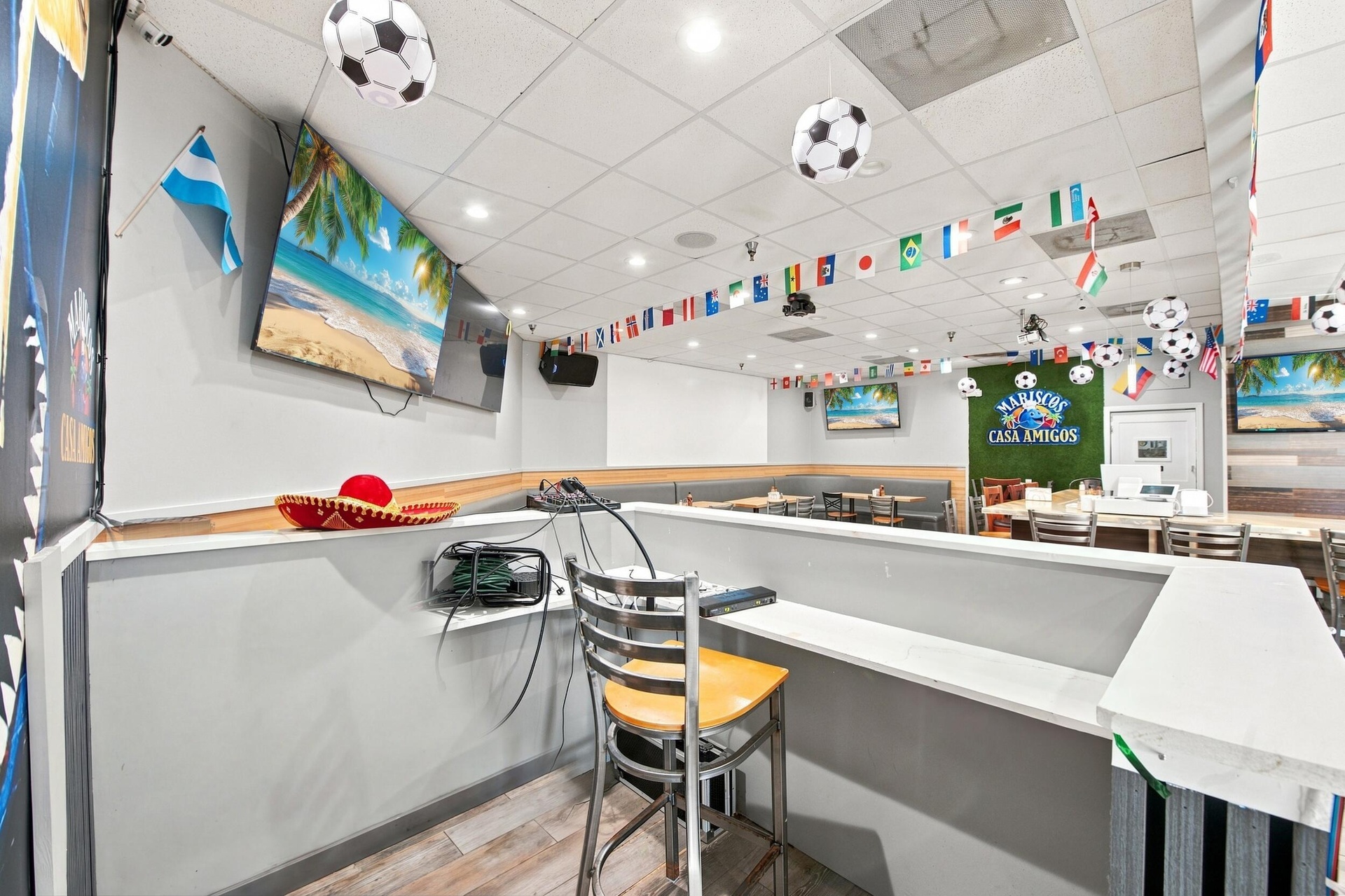 Interior space featuring recessed lighting, drop ceiling panels, wood-finish flooring, and built-in service counter with a neutral-tone surface