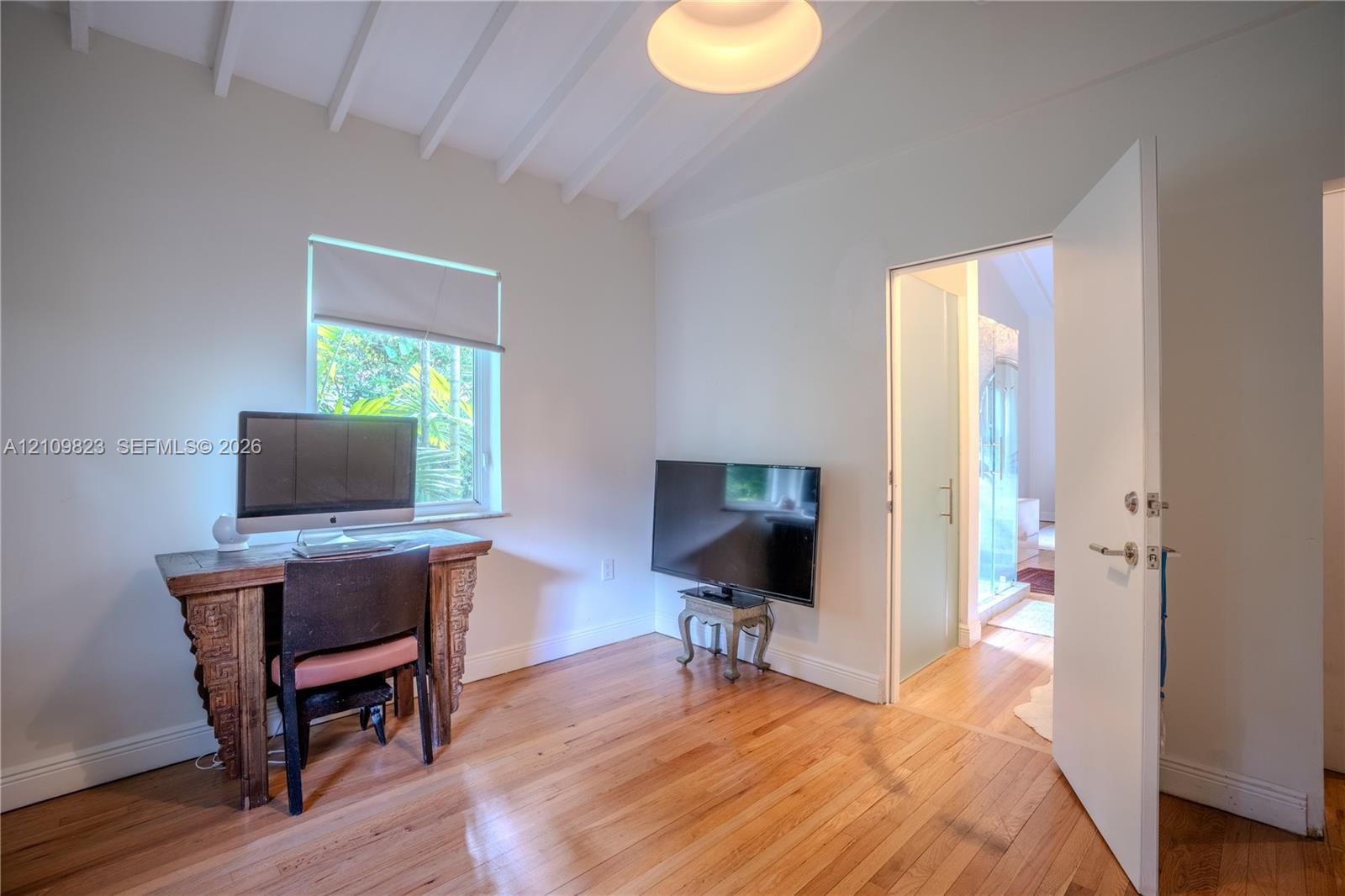 Vaulted ceiling with exposed beams, wood-finish flooring, and recessed ceiling lighting