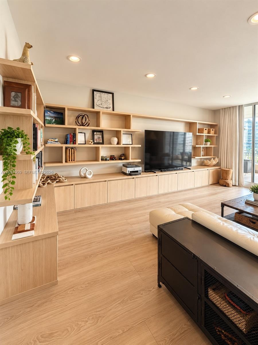 Custom floor-to-ceiling wood-finish cabinetry, extensive open shelving, recessed lighting, and wood-finish flooring