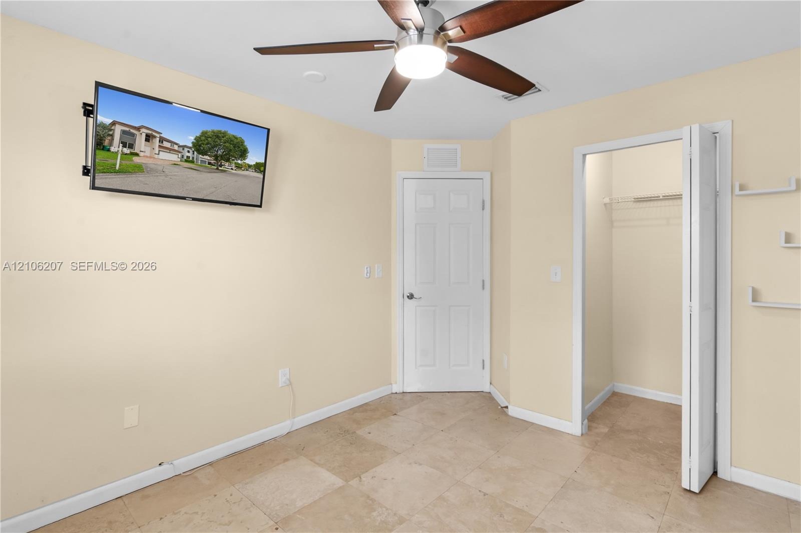 Tile flooring, ceiling fan with integrated lighting, and closet with bi-fold door