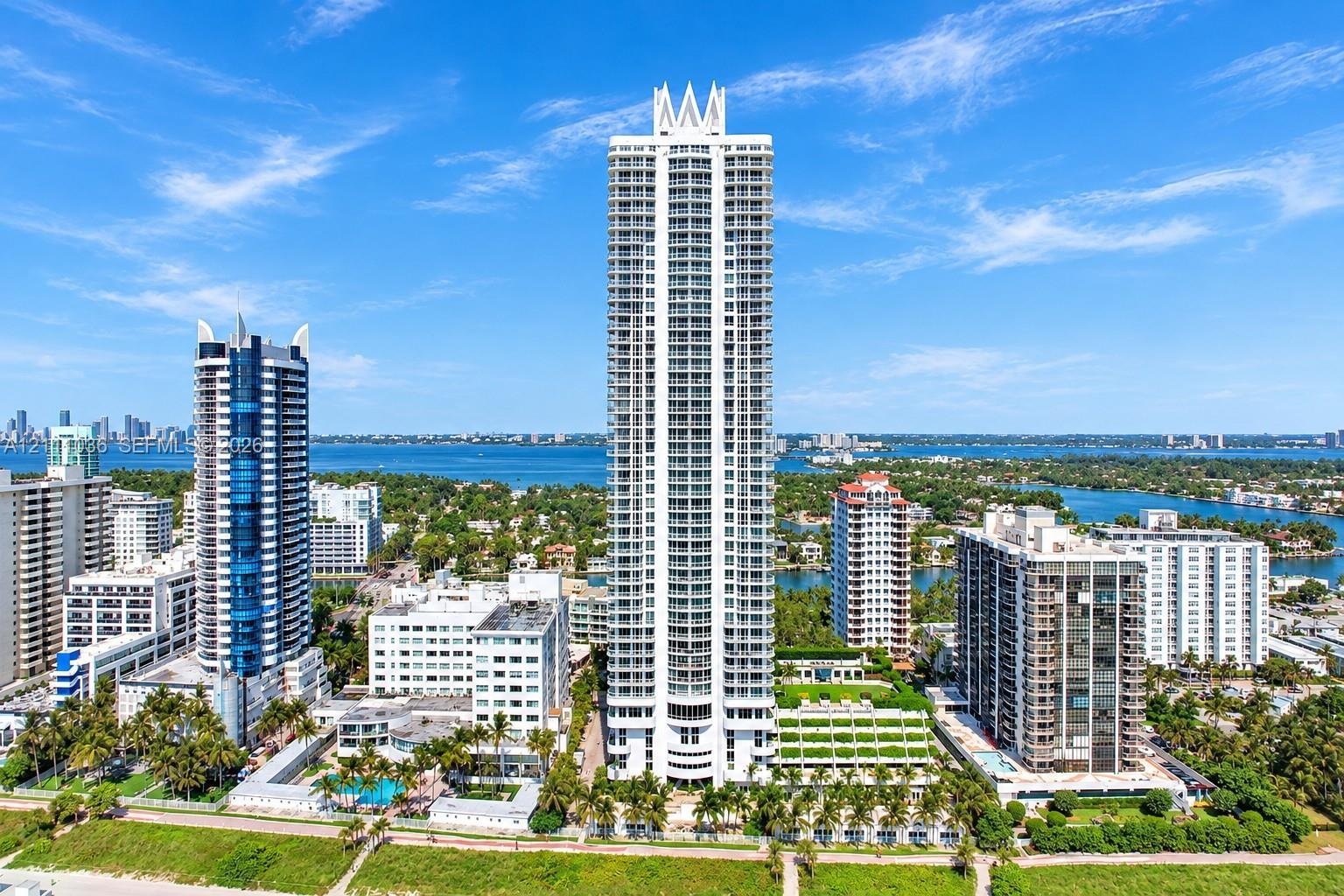 High-rise architectural exterior featuring a prominent crown design, multiple levels of private balconies, concrete construction, and extensive glass 
