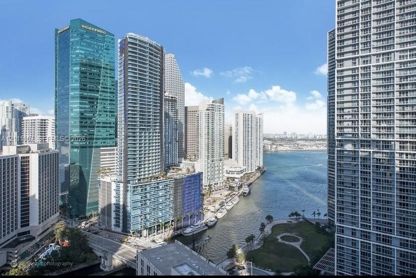 High-rise urban landscape featuring dense metropolitan architecture, waterway access, and waterfront green space