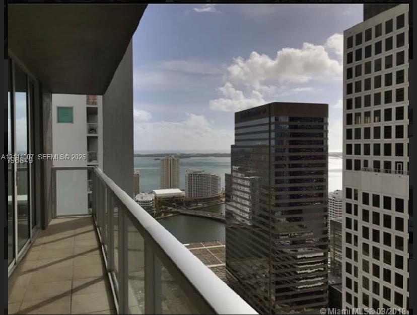 Private balcony featuring neutral tile flooring and a glass-paneled railing