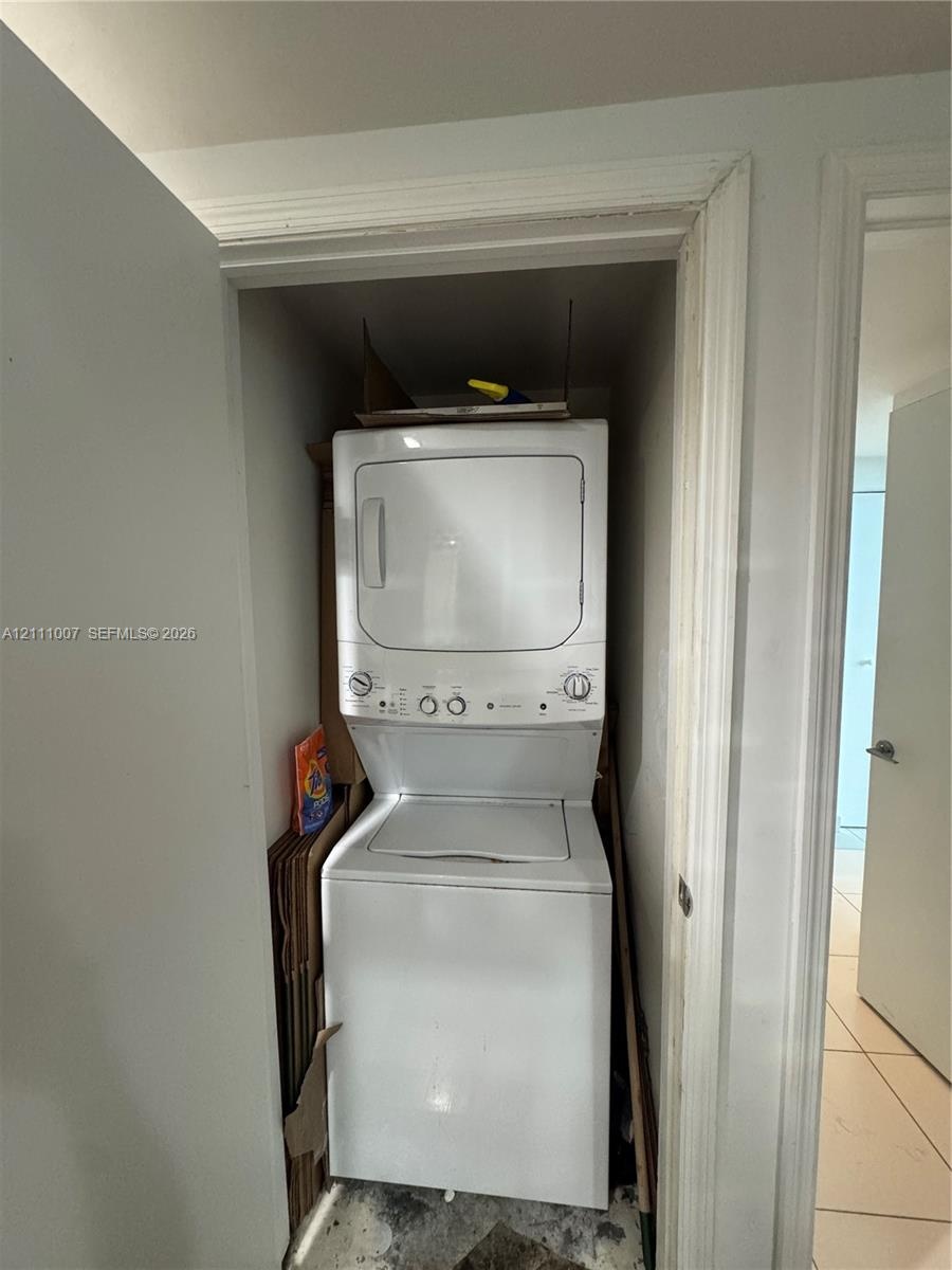 Stacked white laundry unit housed in a dedicated closet