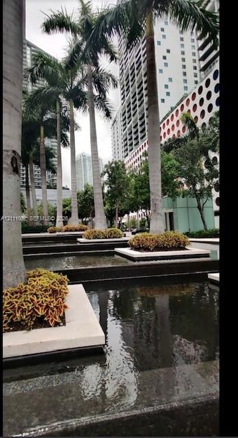 Tiered reflecting pools featuring stone coping, integrated landscape planters, and mature palm trees
