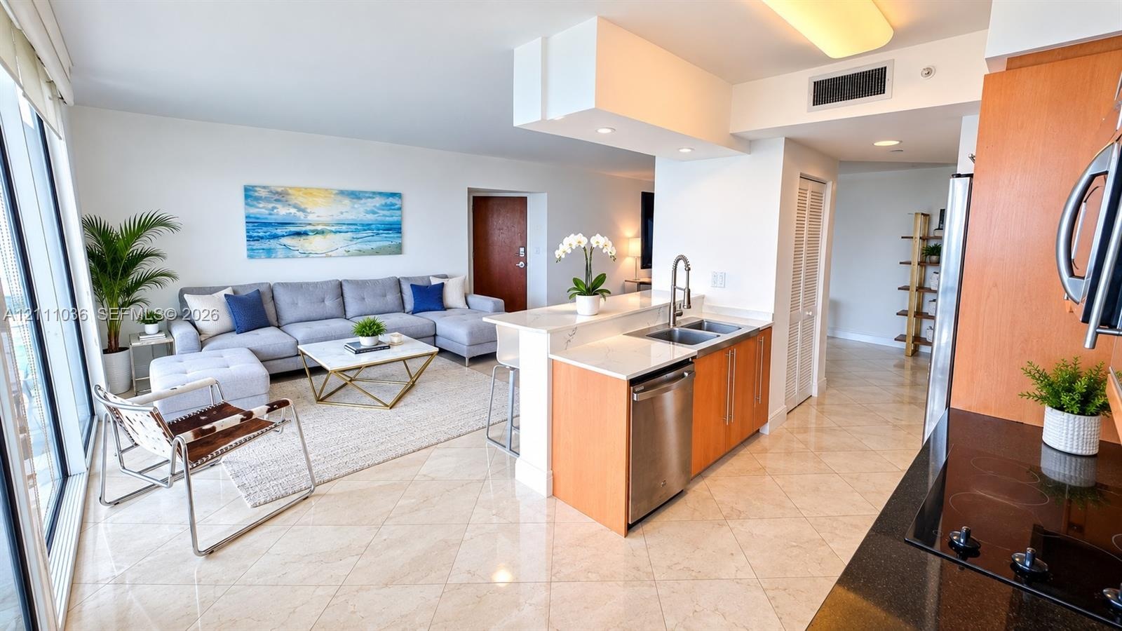 Kitchen featuring light-finish cabinetry, stone-surface countertops, dual-basin stainless steel sink with pull-down faucet, stainless steel dishwasher