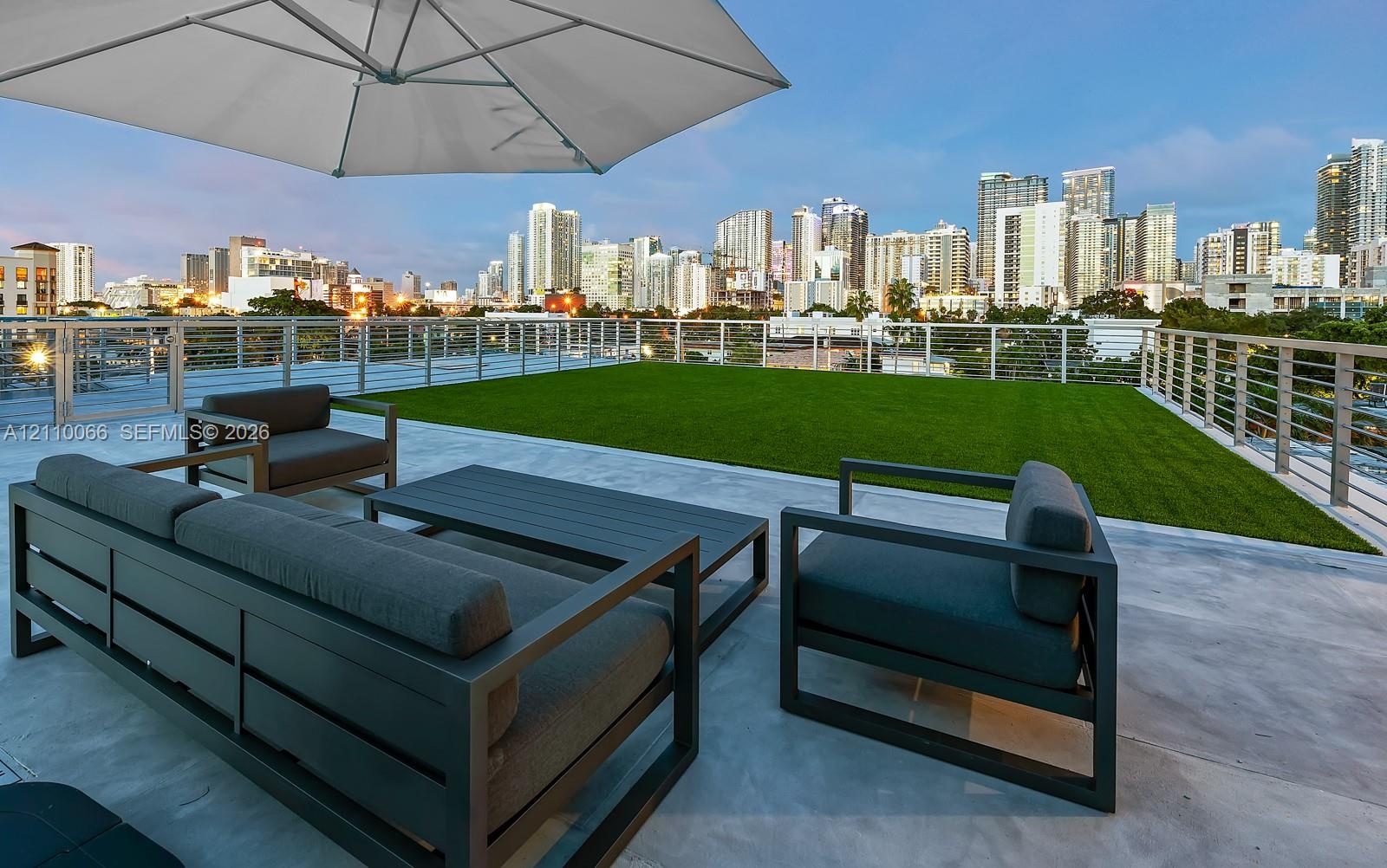 Rooftop terrace featuring concrete flooring, artificial turf, and stainless steel cable railing